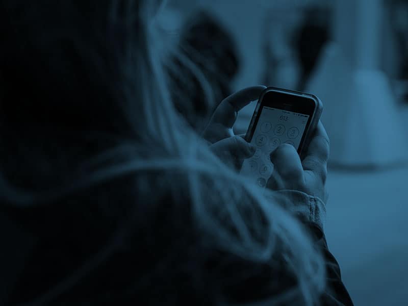 A woman holding a cell phone in her hand.