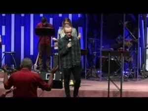 A group of people singing on stage at a church.