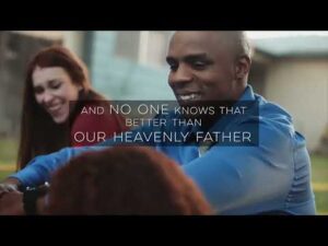 A man and two women sit outdoors smiling, with overlaid text that reads: "And no one knows that better than our Heavenly Father.